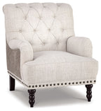 Upholstered accent chair in light gray fabric with tufted back and nailhead trim on arms