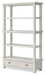 Antique white bookcase with open shelves and lower drawer with round knobs.