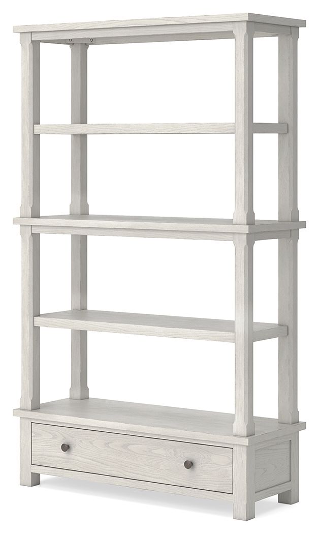 Antique white bookcase with open shelves and lower drawer with round knobs.