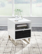 White chair side end table with open shelf, black drawer, and items on top