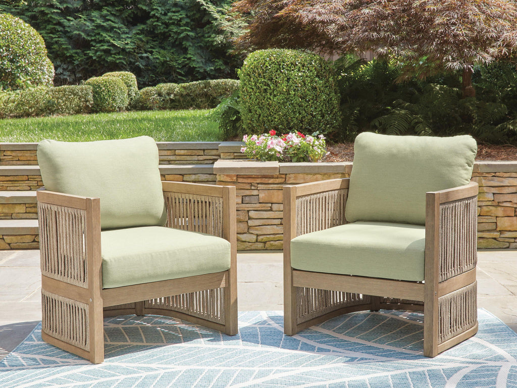 Two beige lounge chairs with green cushions, slatted sides, and armrests