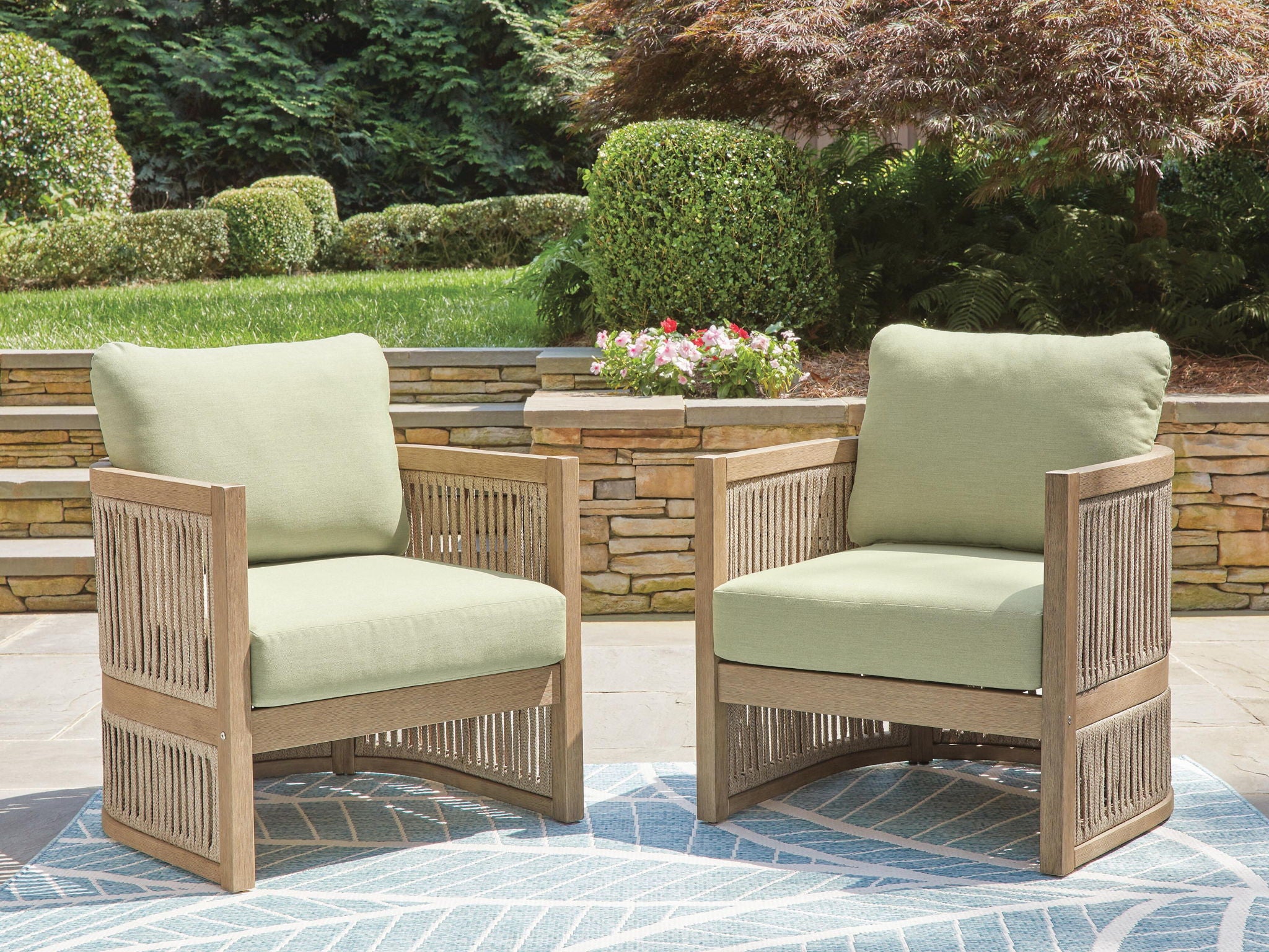 Two beige lounge chairs with green cushions, slatted sides, and armrests