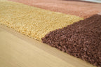 Geometric area rug edge with low pile in yellow and dark brown sections
