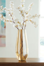 Amber glass vase with flared opening holding white blossoms