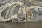 Faelyn rug edge with low pile and gray, cream, and tan abstract swirl design