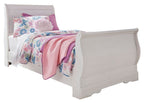 White sleigh bed with curved headboard and footboard, with pink floral bedding.