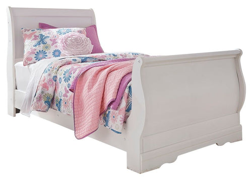 White sleigh bed with curved headboard and footboard, with pink floral bedding.