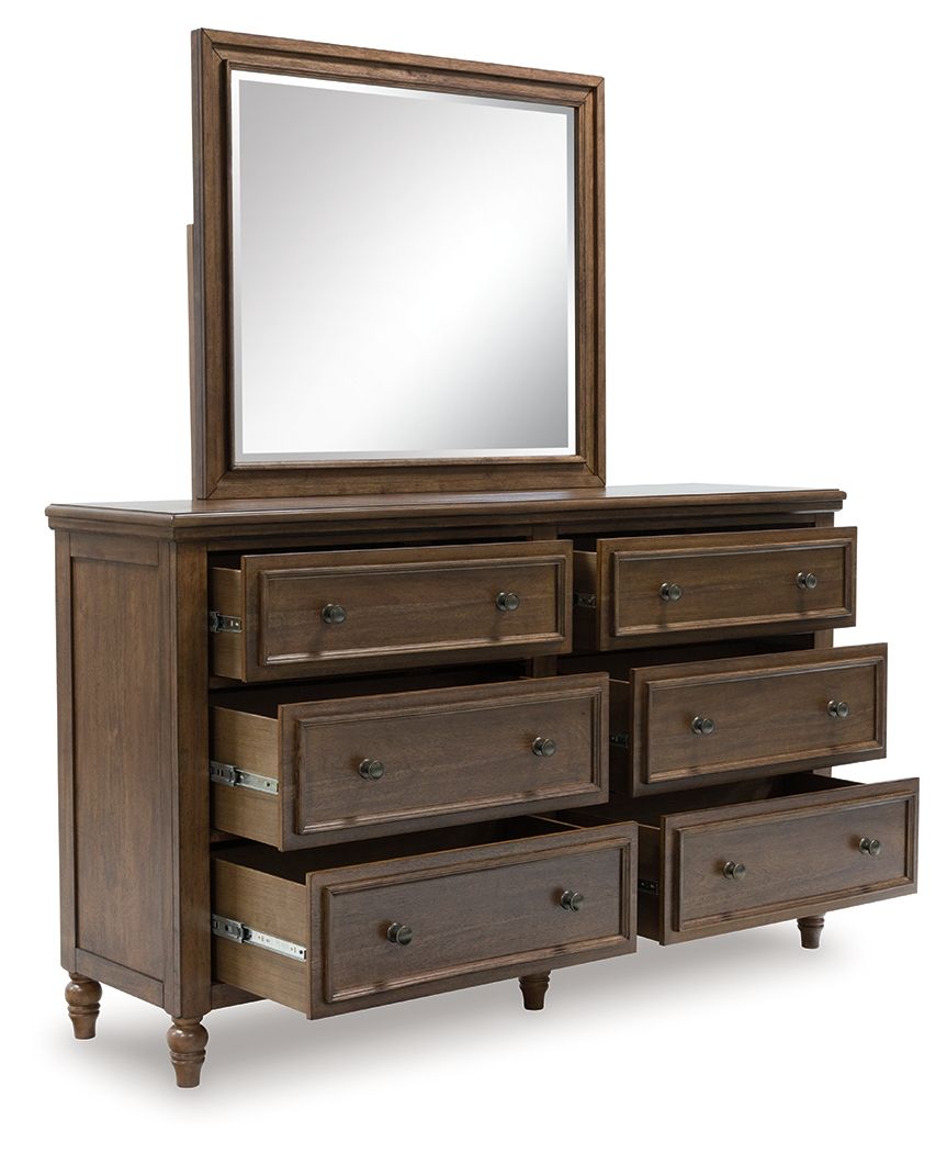 Brown wooden dresser with framed mirror and multiple drawers with metal pulls