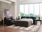 Glennbre queen sofa sleeper with pulled-out bed and gray mattress, dark upholstery.