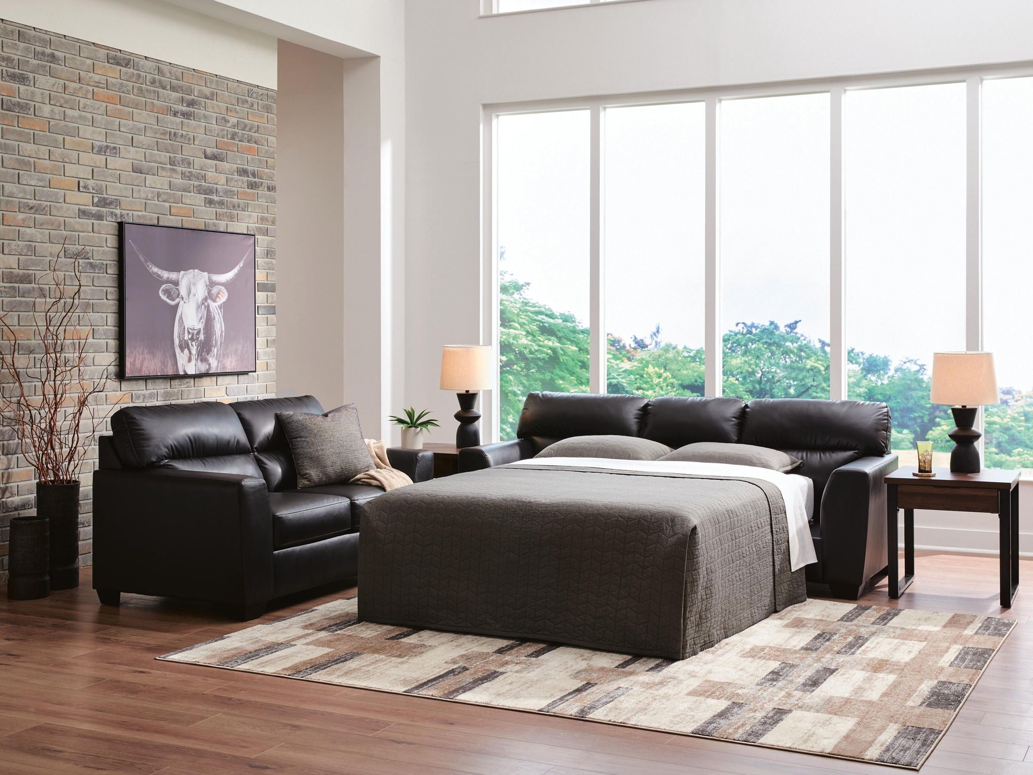 Glennbre queen sofa sleeper with pulled-out bed and gray mattress, dark upholstery.