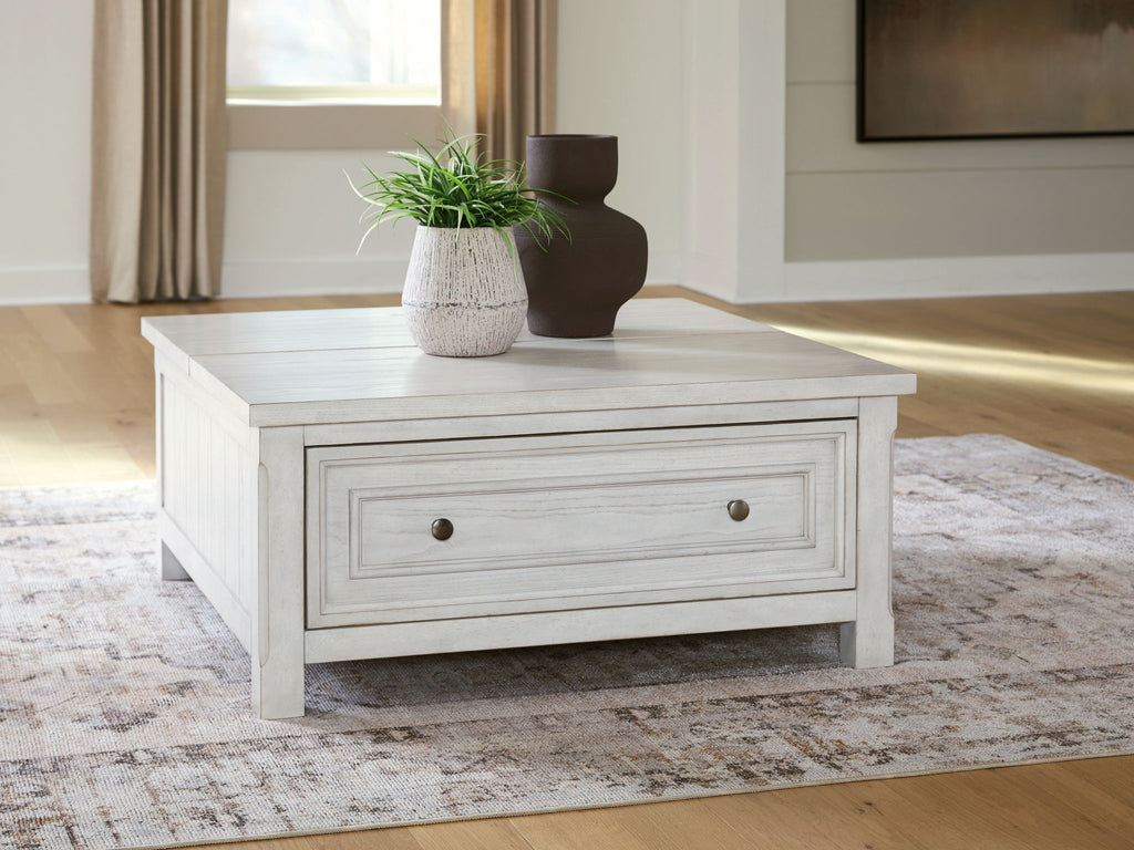 White coffee table with a long drawer and metal knobs on a paneled front.