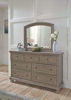 Arched mirror over light gray dresser with multiple drawers and silver knobs