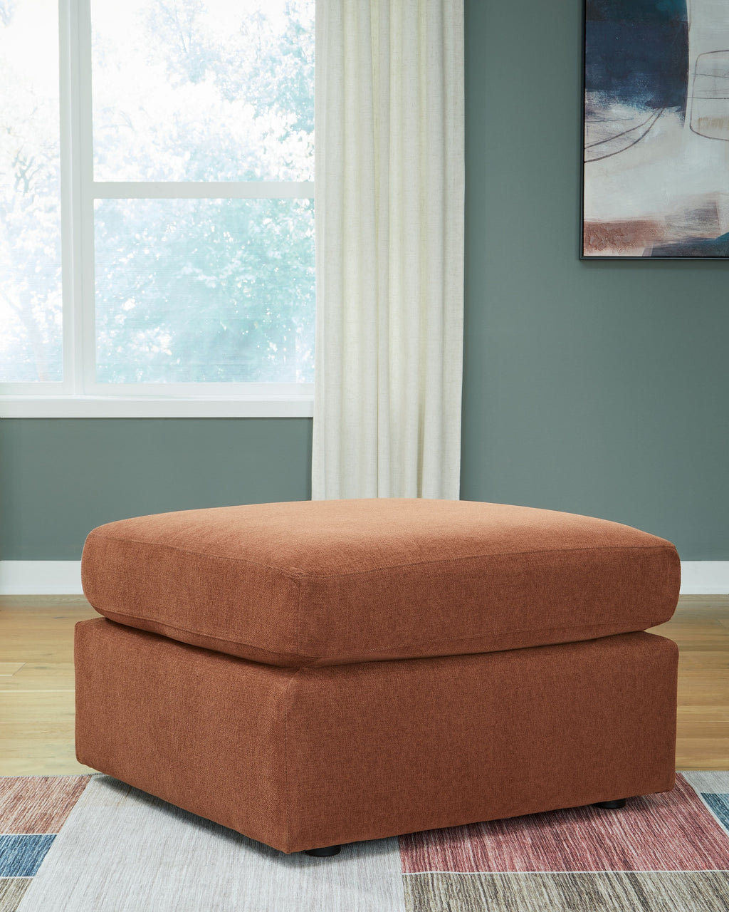 Brown accent ottoman with cushioned top and square base, dark feet.