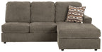 Gray sofa chaise with deep seat cushion and patterned throw pillow on arm