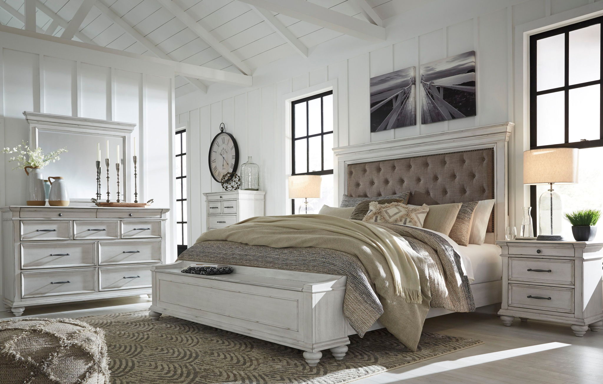 Upholstered panel bed in white with tufted taupe headboard and neatly styled bedding