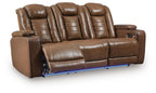 Brown reclining sofa with padded armrests and adjustable headrests, power buttons on side