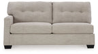 Pebble upholstered sofa with tufted backrest, wide arms, and dark tapered legs