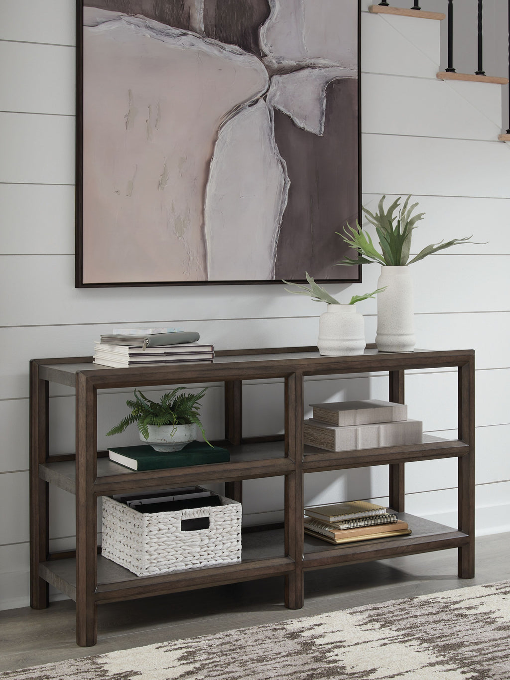 Sofa table with brown frame, gray shelves, and open storage under decor items