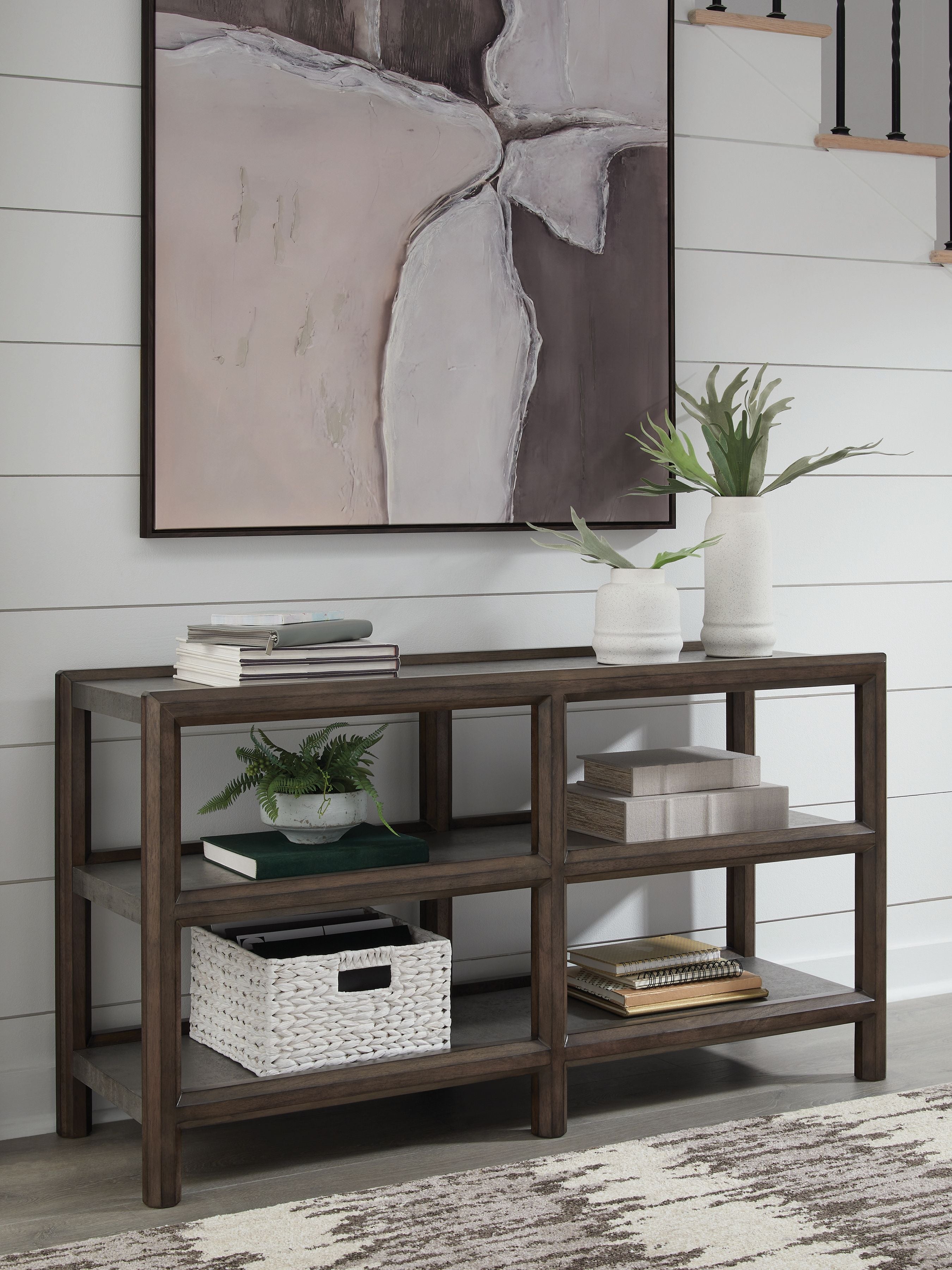 Sofa table with brown frame, gray shelves, and open storage under decor items