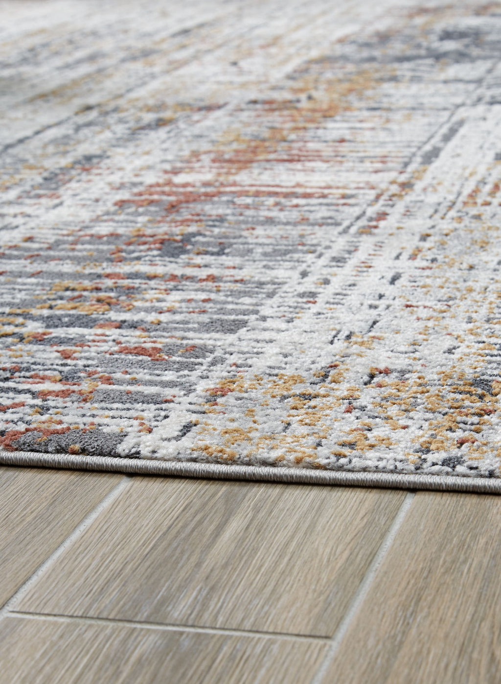 Abstract multi-color area rug close-up, gray and white with orange and yellow flecks