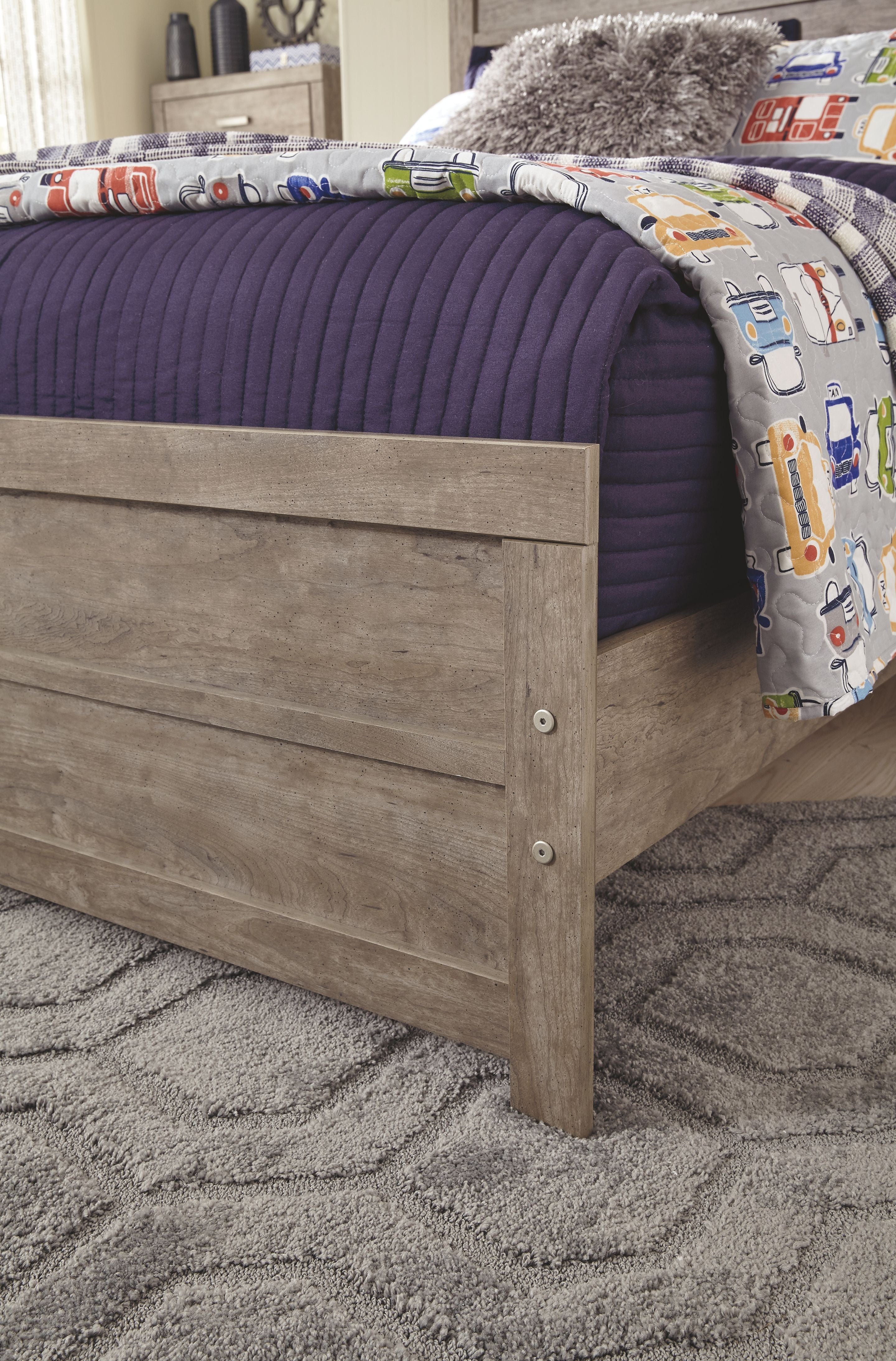 Gray wood panel headboard and footboard on a bed with quilted bedding