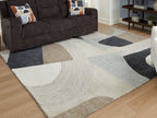 Geometric beige area rug with dark gray and light blue shapes and textured wavy line pattern