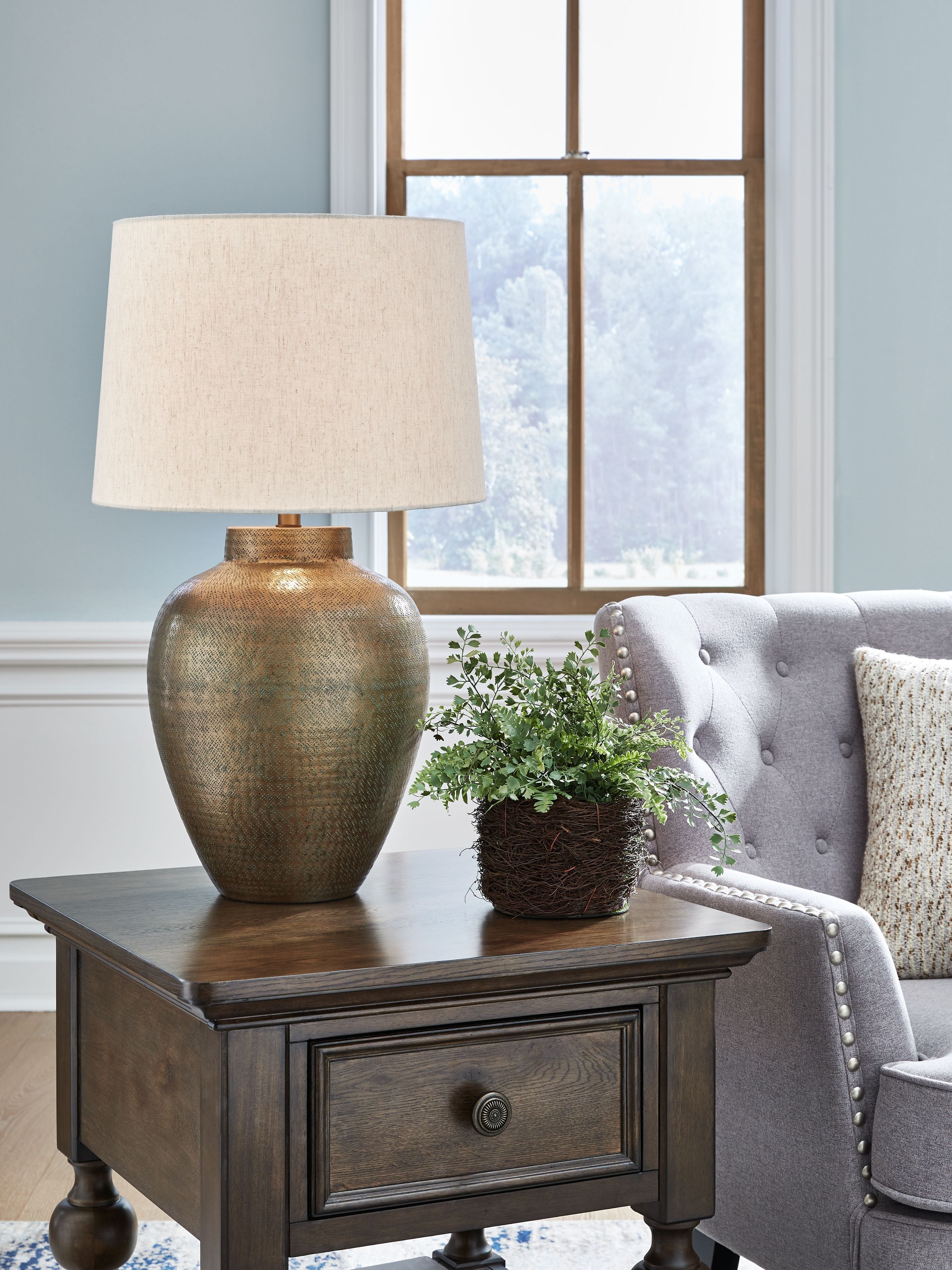Antique gold metal table lamp with white fabric shade on side table