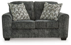 Textured gunmetal gray loveseat with two patterned throw pillows and armrests