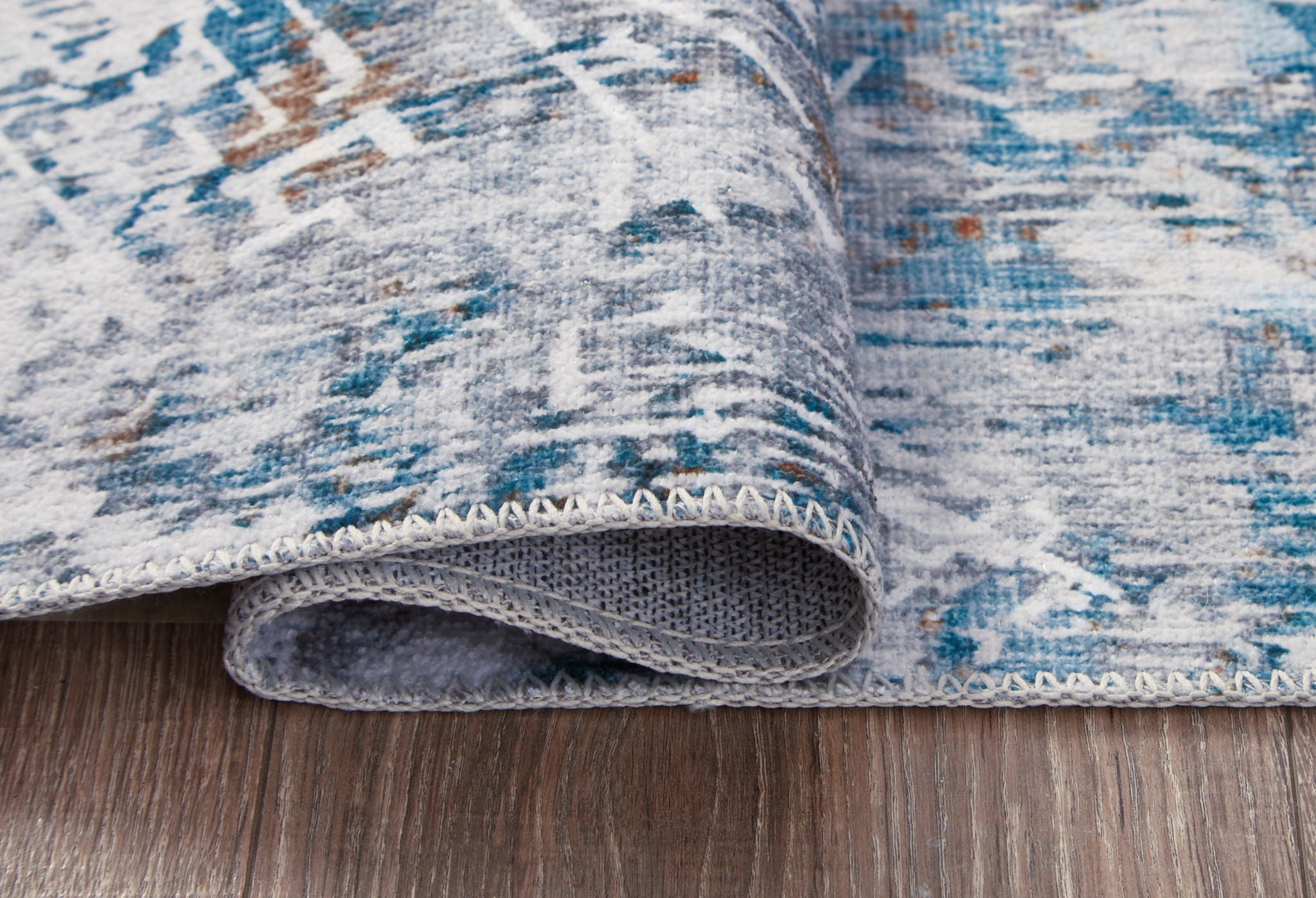 Blue and white rug edge with stitched binding and short pile