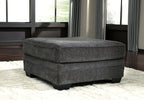 Dark gray upholstered ottoman with cushioned top and low block feet
