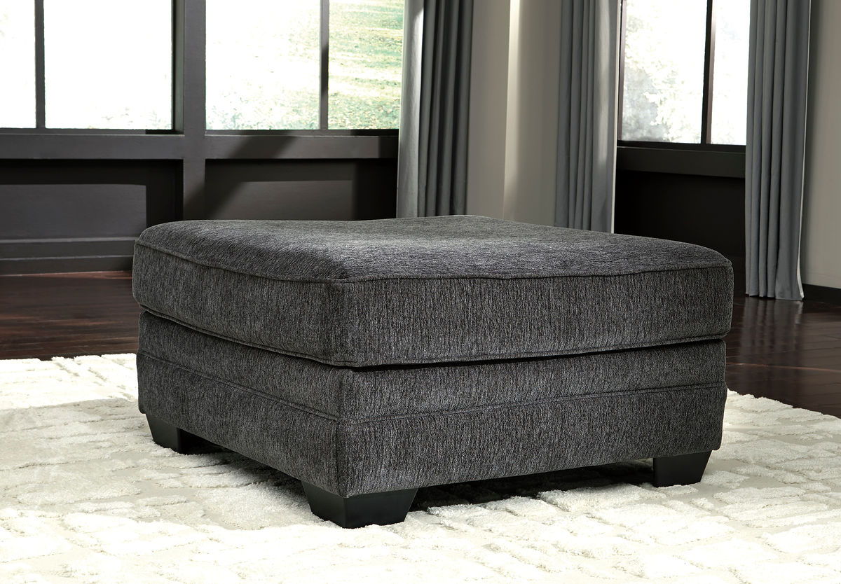 Dark gray upholstered ottoman with cushioned top and low block feet