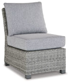 Light gray outdoor sofa chair with wicker base and padded seat