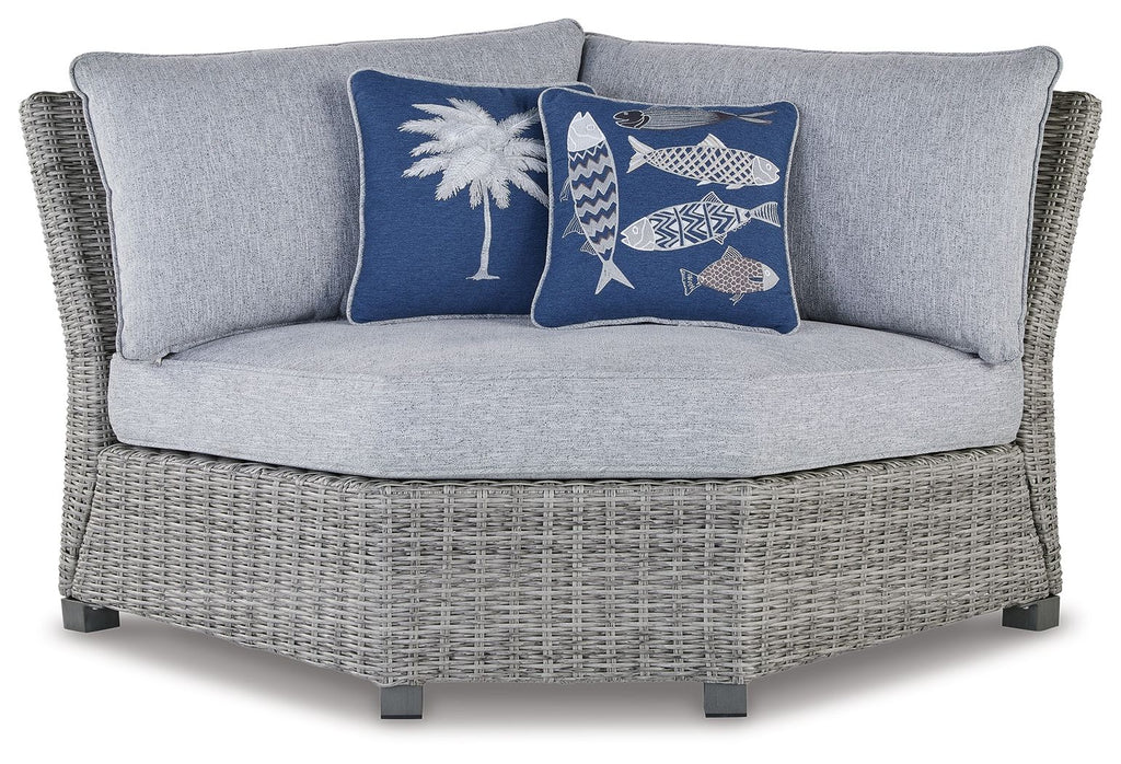 Light gray outdoor corner chair with blue fish and palm accent pillows