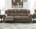 Taupe-gray power reclining sofa with padded arms and tufted, segmented back design.