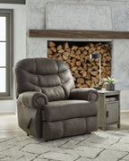 Gunmetal zero wall recliner chair with padded arms, tufted cushions, and recline footrest.