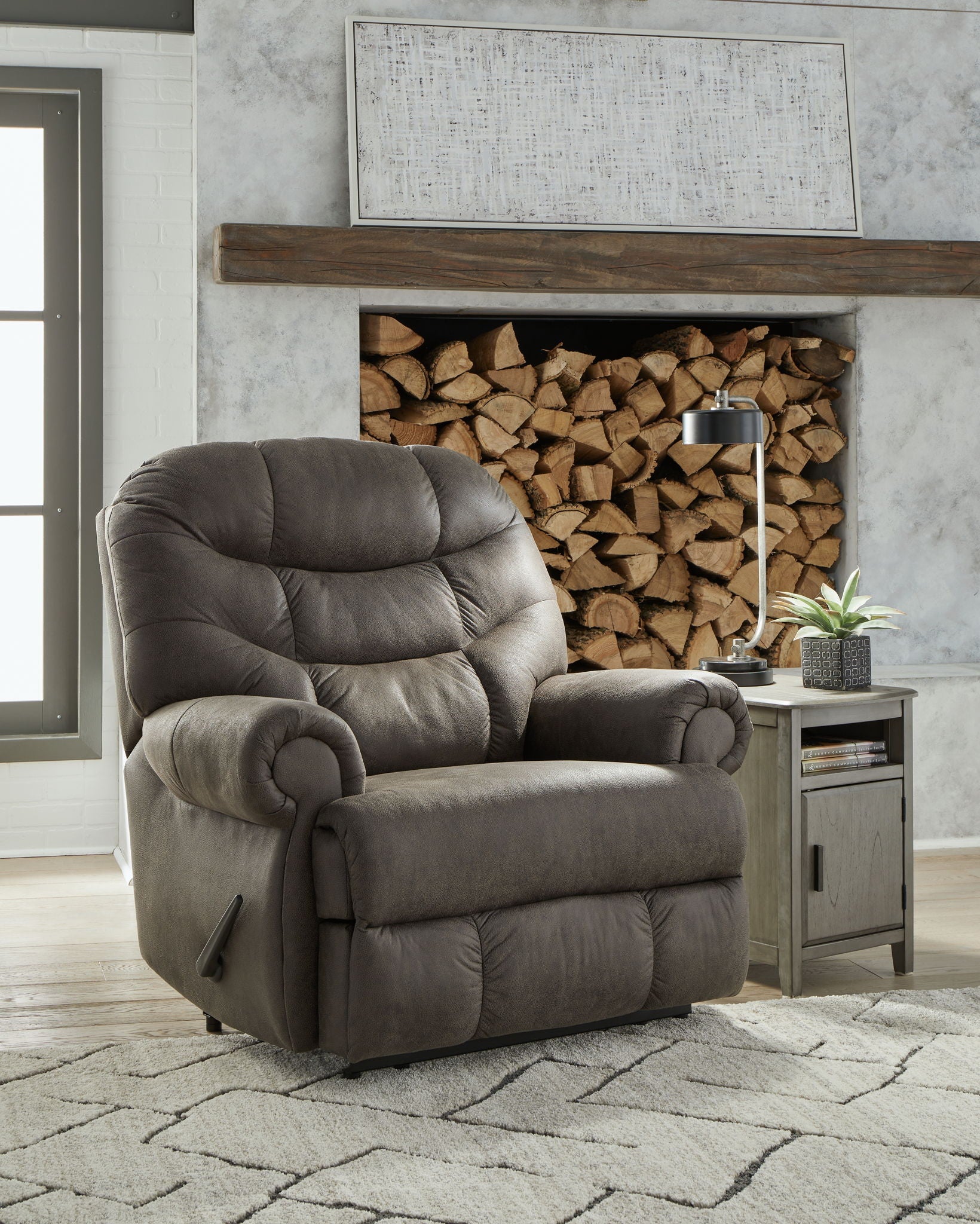 Gunmetal zero wall recliner chair with padded arms, tufted cushions, and recline footrest.