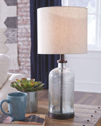 Clear glass table lamp with beige fabric shade and bronze neck