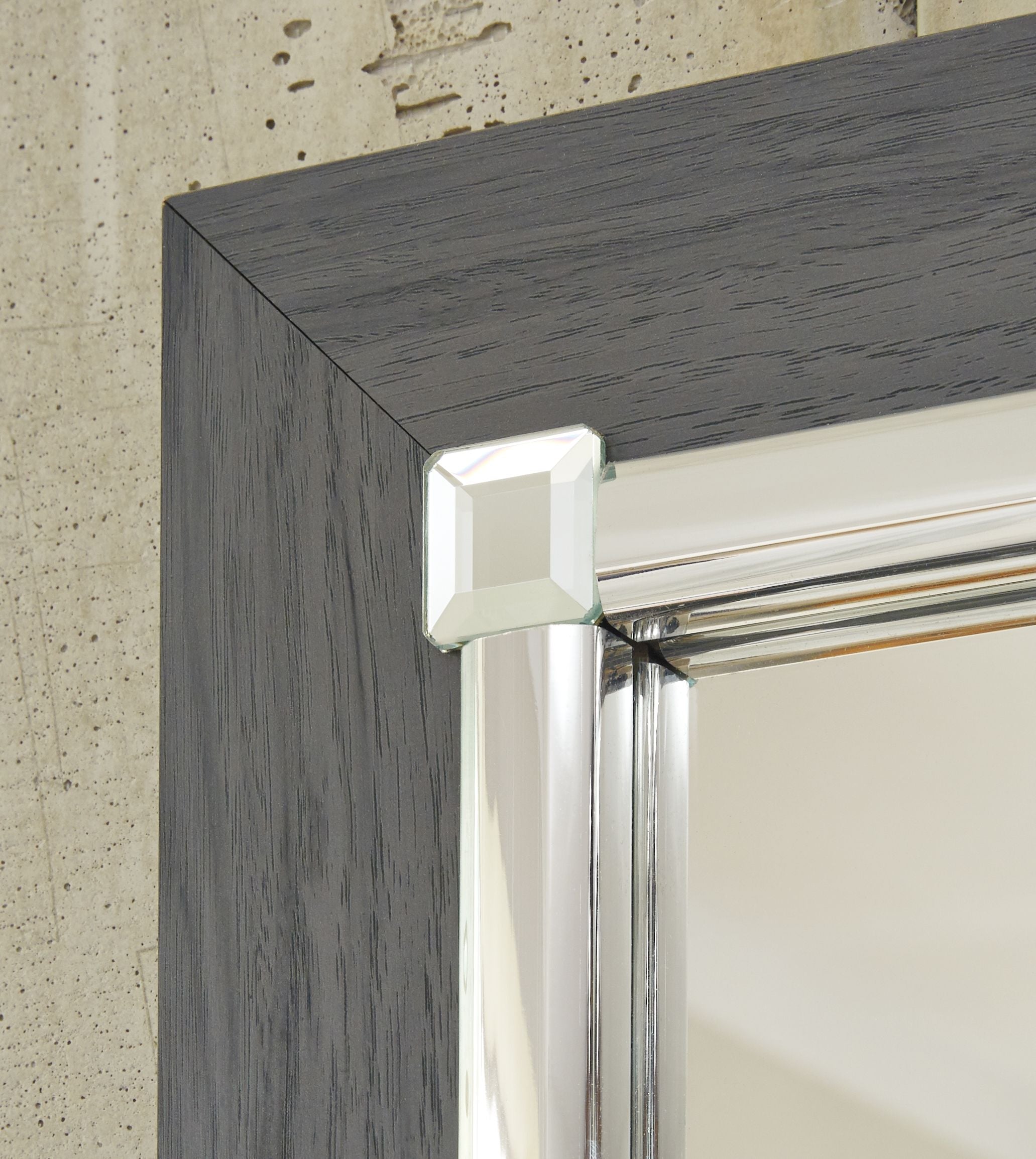 Chrome corner trim on gray dresser mirror frame with reflective metal rail