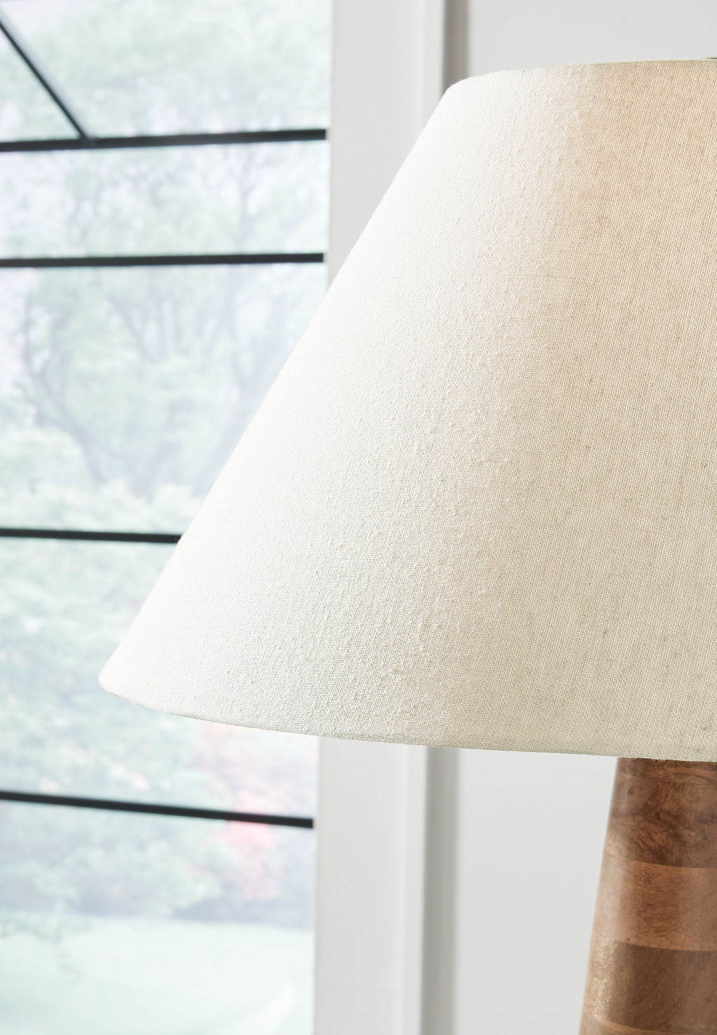 Cream fabric lamp shade over dark brown wooden base