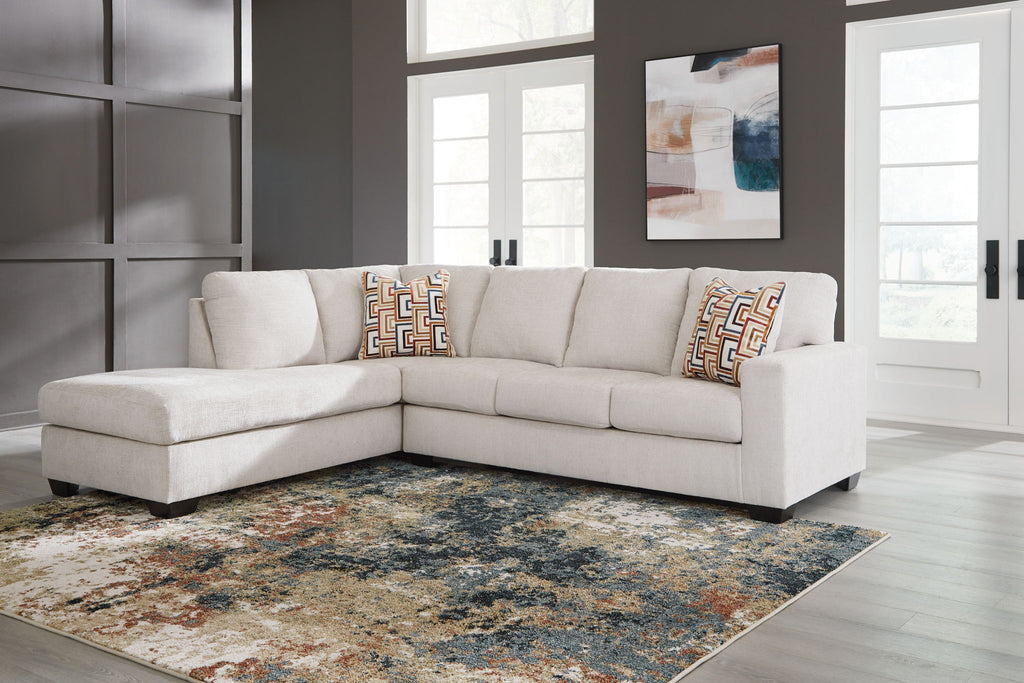 Light beige corner sectional sofa with patterned accent pillows and chaise section