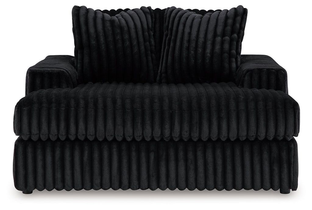 Oversized chaise with ribbed black fabric and deep seat; two back pillows included.