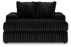 Oversized chaise with ribbed black fabric and deep seat; two back pillows included.