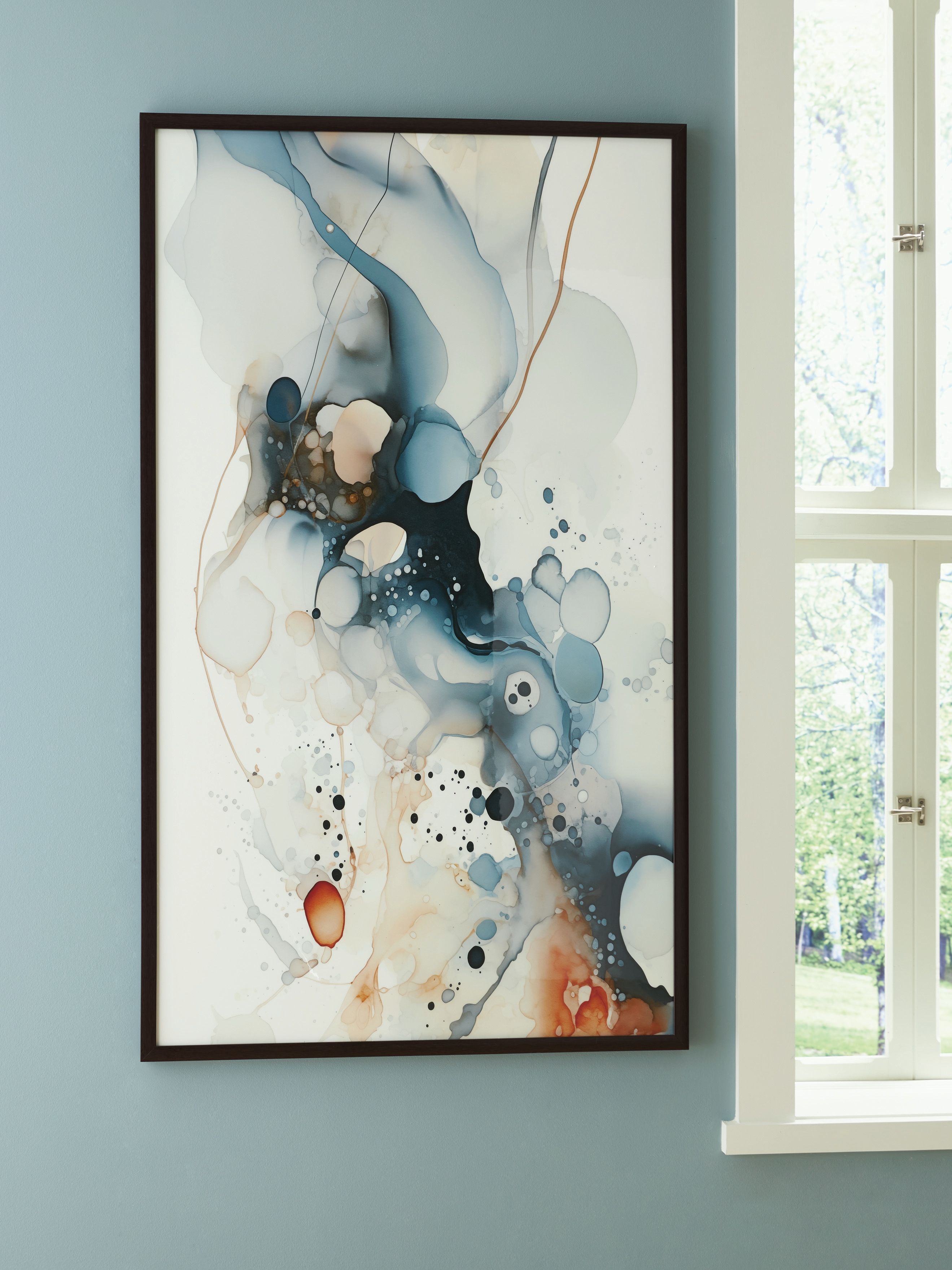 Framed abstract blue wall art with speckled ink and white circular forms.