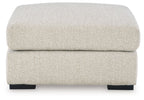 Oversized accent ottoman with rounded top cushion and dark block feet, pebble upholstery.