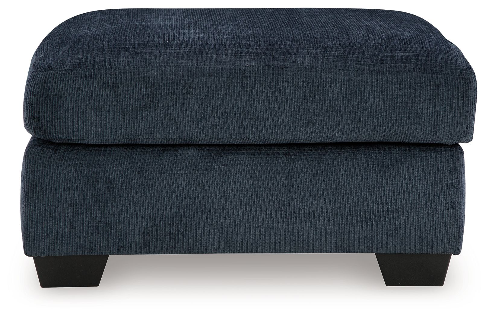 Dark navy upholstered ottoman with rounded square lid and dark block legs.