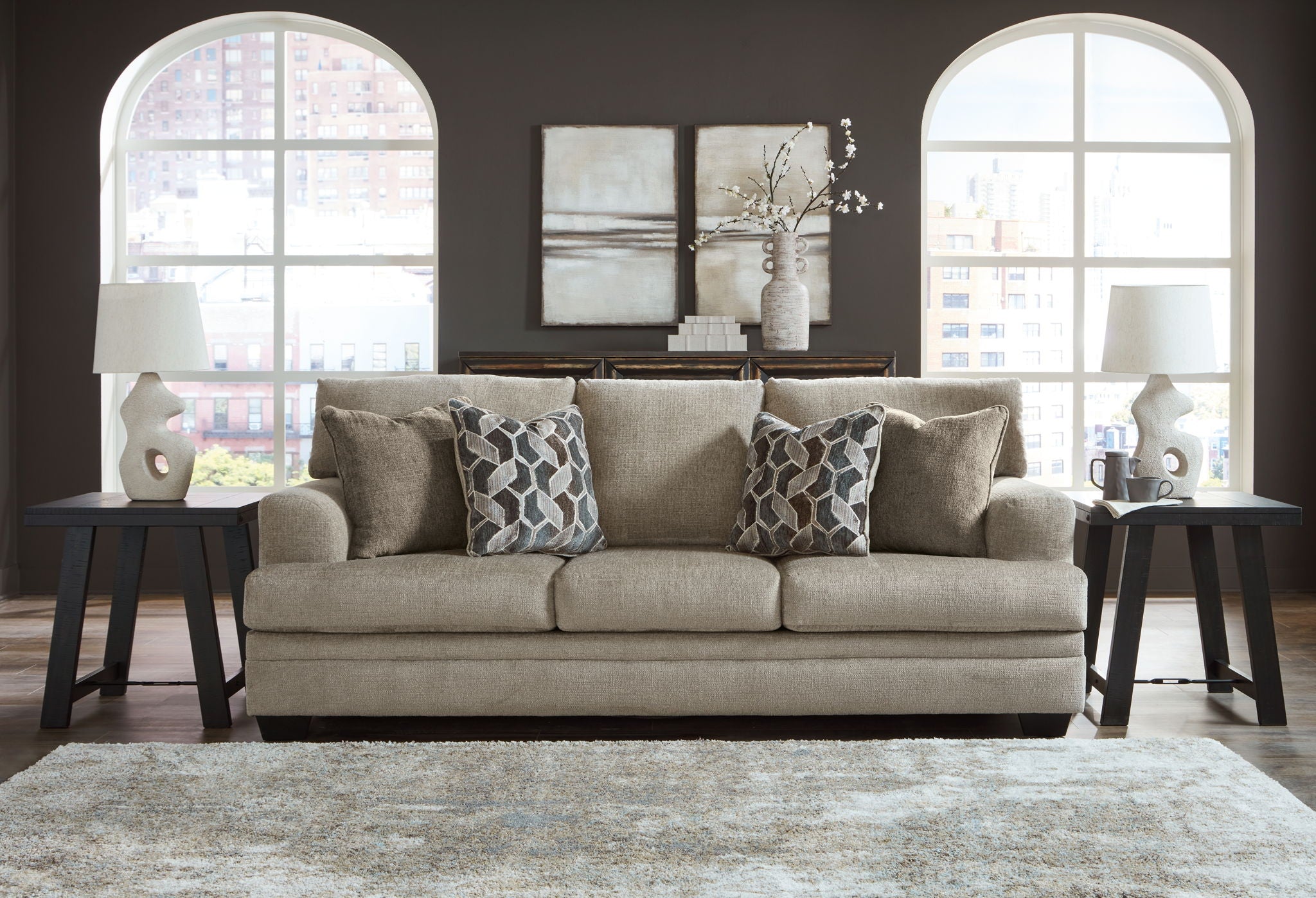 Sectional sofa with chaise in light brown fabric, decorative geometric patterned pillows