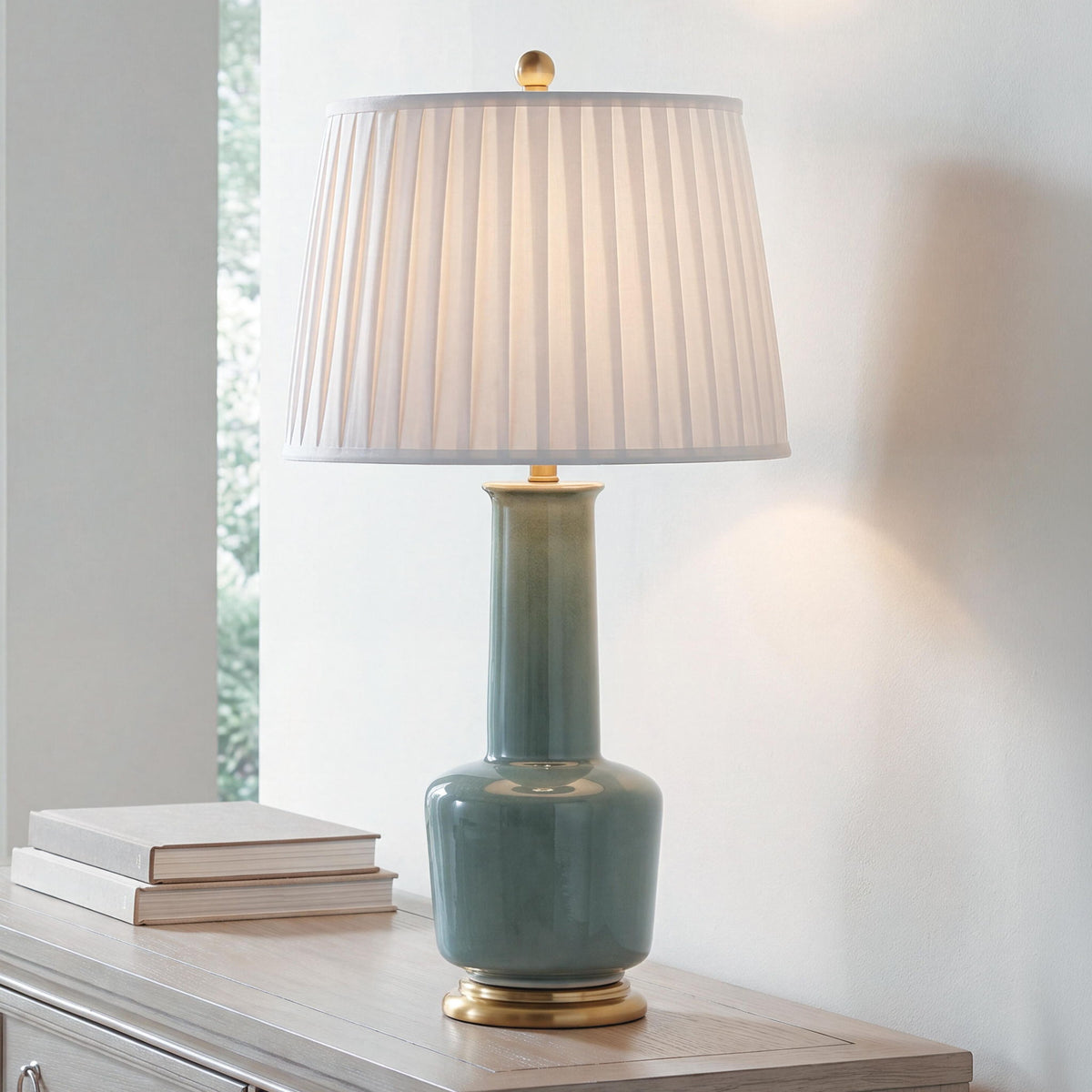 Teal ceramic table lamp with pleated white drum shade and gold accent base