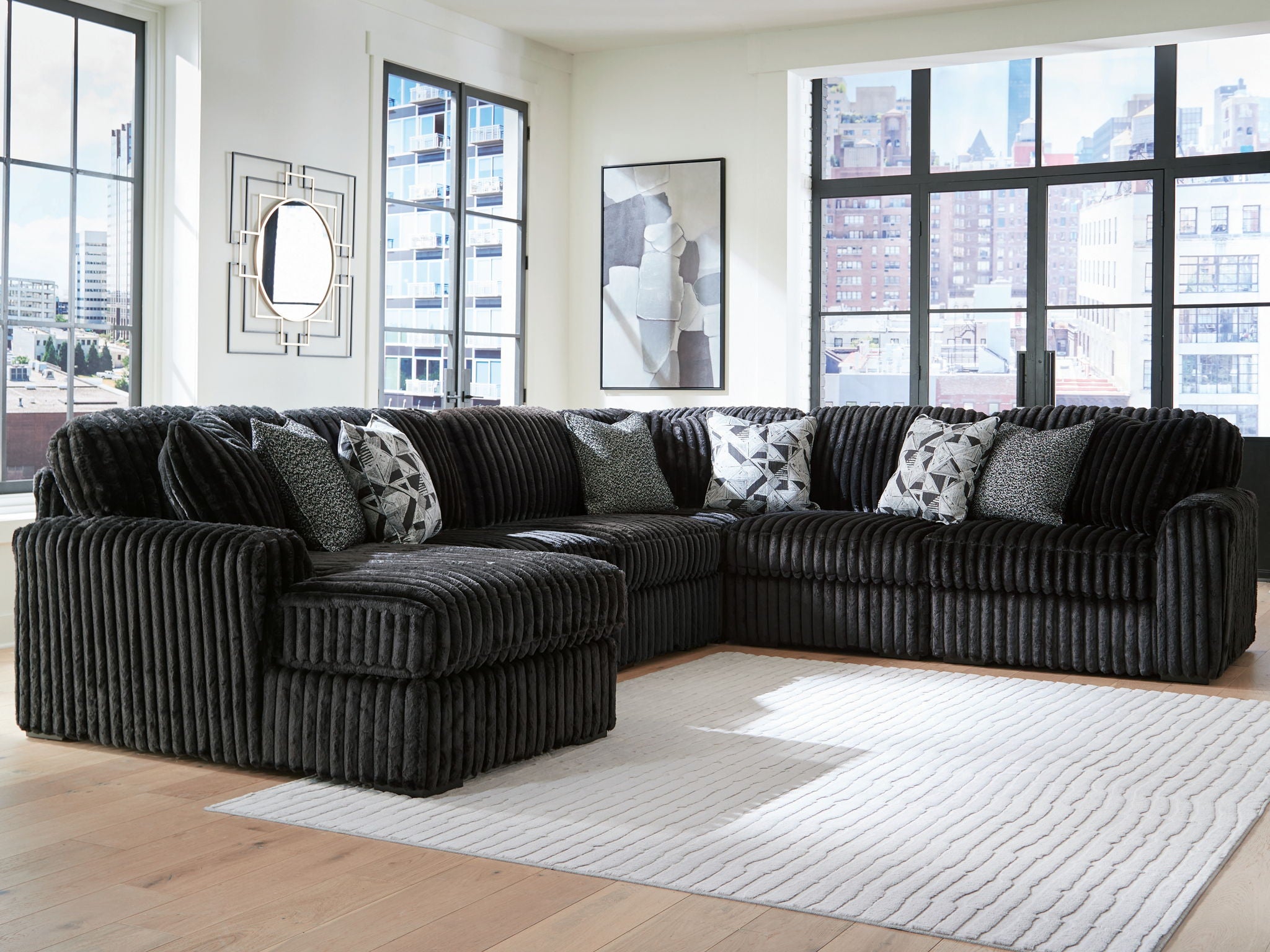 Sectional sofa with chaise, black corded upholstery and patterned accent pillows