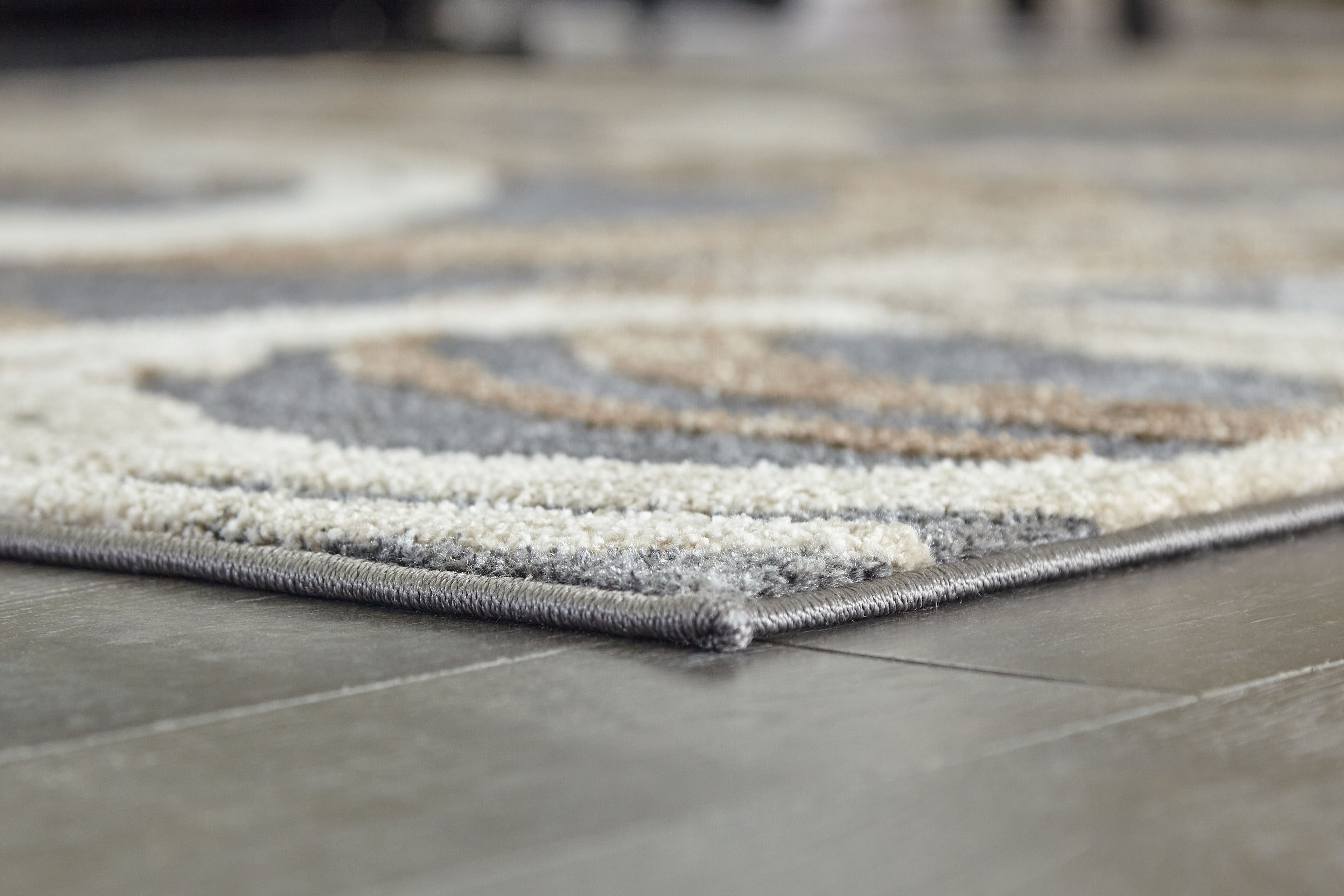 Faelyn rug corner detail, low pile with gray and cream abstract swirl border