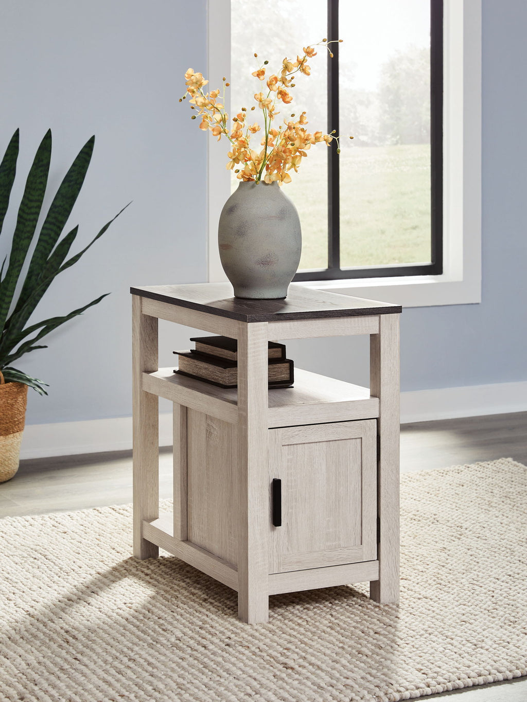 Chair side end table with open shelf and single door cabinet, white finish, black handle.